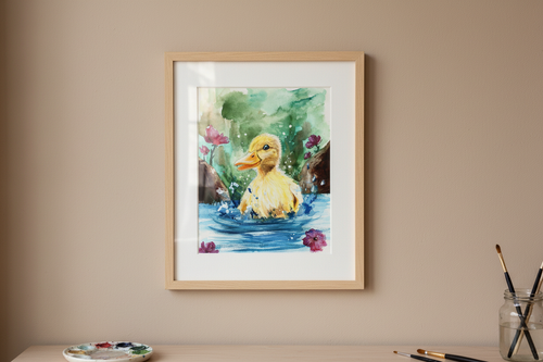 Framed watercolour print of a duckling in a pond hanging in a simple art studio